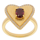 Heart-shaped gold ring featuring an oval red garnet center stone surrounded by sparkling accents.